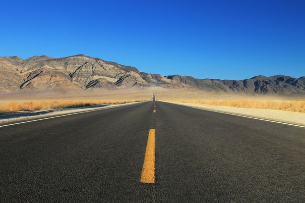 A shot of a Nevada road stretching ot the horizon.